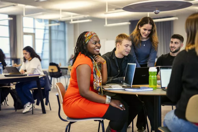 Studenter runt ett bord som samarbetar 